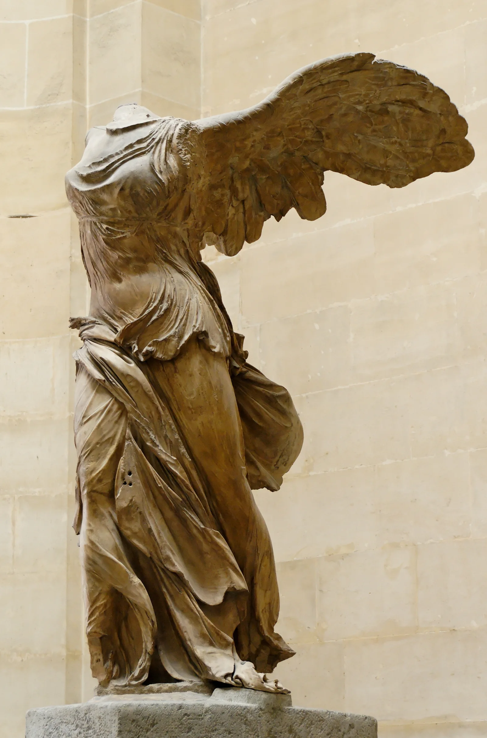 The headless marble Winged Victory of Samothrace, wings spread wide, standing on a stone ship’s prow